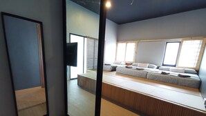 Een moderne kamer met een groot bed, een zithoek en een grote spiegel.