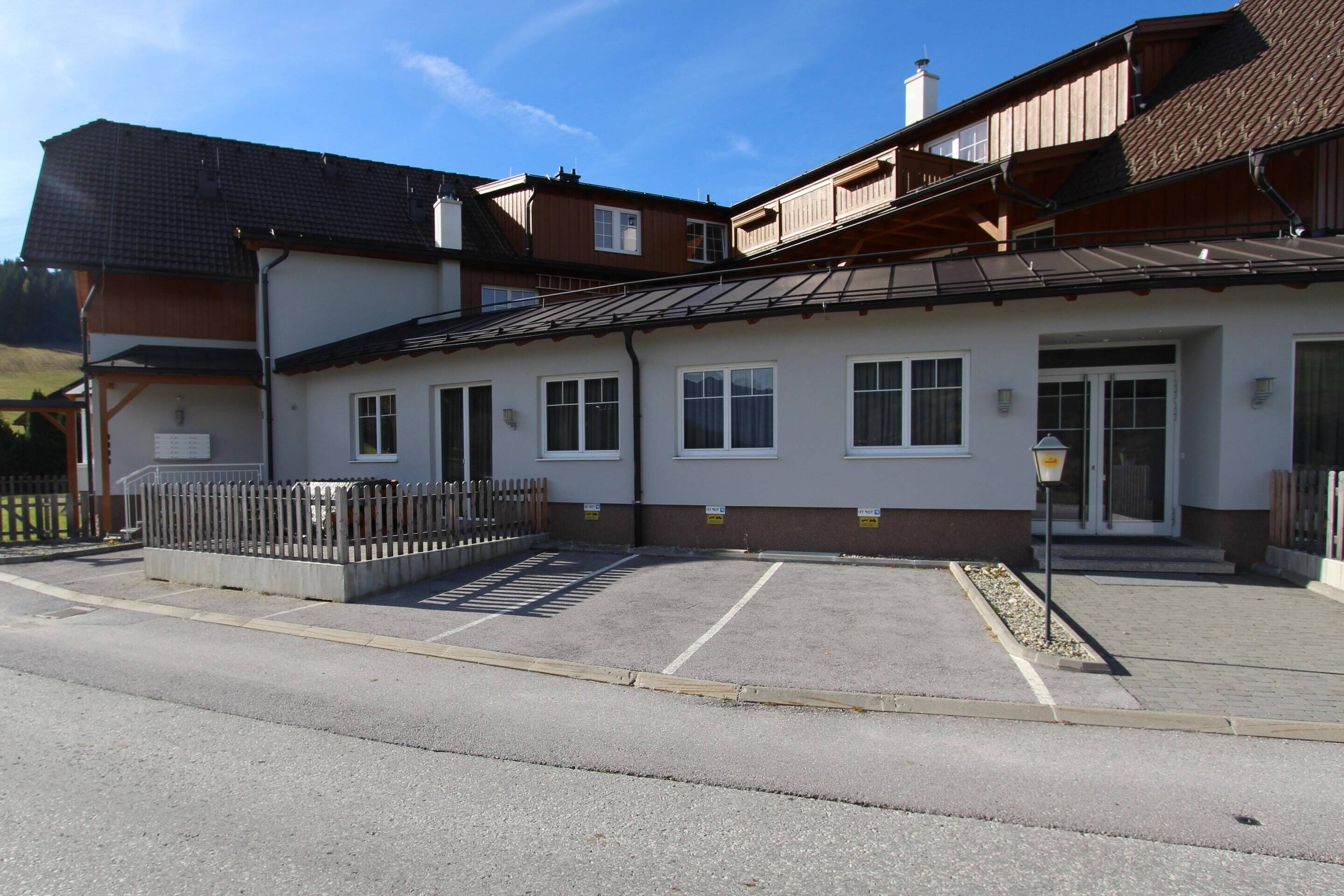 A two-story building with a parking area in front.