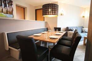 Enjoy meals with family and friends at this dining area, featuring a long table and comfortable seating for four.