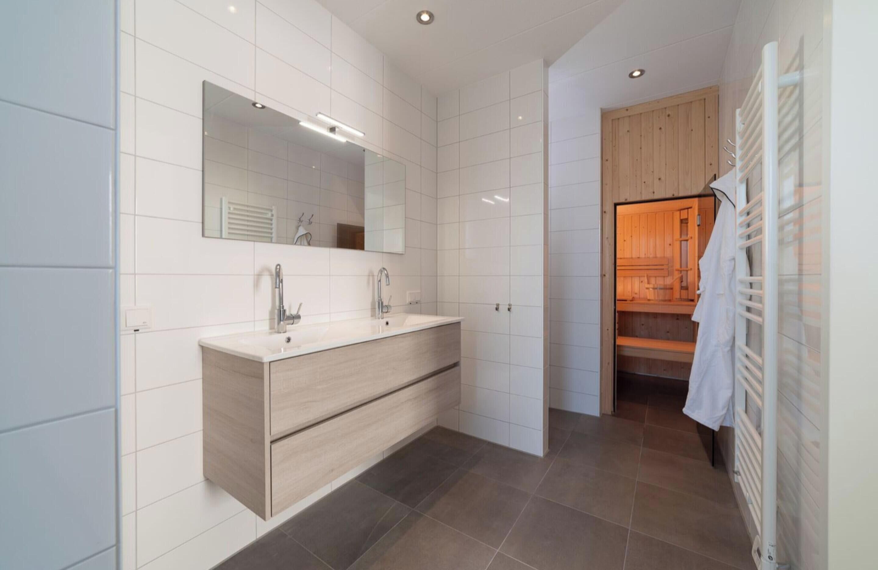 A modern bathroom with a large mirror, a wooden vanity, and a walk-in shower.