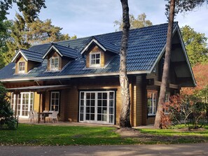 Enjoy a serene setting surrounded by trees and a well-maintained lawn from this two-story house with a covered patio and large windows.