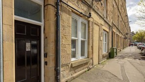 A narrow street with a row of buildings, a black door, and a window with a white frame. - Balfour · Stylish and Comfortable City Centre Apartment (Edinburgh)
