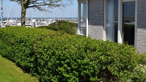 Un bâtiment moderne doté de grandes fenêtres et offrant une vue sur une marina remplie de bateaux.