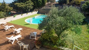 Una piscina con lettini e un solarium in legno.