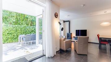 A modern living room with a sliding glass door leading to an outdoor area, a fireplace, and a dining area.