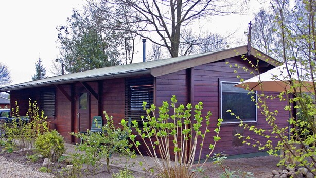 A rustic house with a sloped roof, wooden siding, and a front porch.