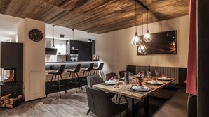 Un espace de restauration moderne avec un plafond en bois, une cuisine en arrière-plan et un coin bar avec des sièges.