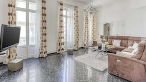 A living room with a sofa, TV, and curtains. - Apartment in Nice Near Beaches (Nice)