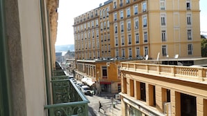 A multi-story building with balconies, a street in the foreground, and a clear view of the street. - Apartment in Nice Near Beaches (Nice)