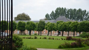 En innergård med en byggnad i tegel, en gångstig och en rad träd.