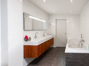 A modern bathroom with a double vanity, a large mirror, and a freestanding bathtub. - Water Villa Kortgene by Veerse Meer (Kortgene)
