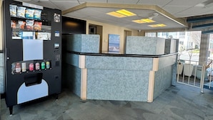 A modern office space with a vending machine, cubicles, and a view of the outside. - Impala Island Inn (Ocean City)