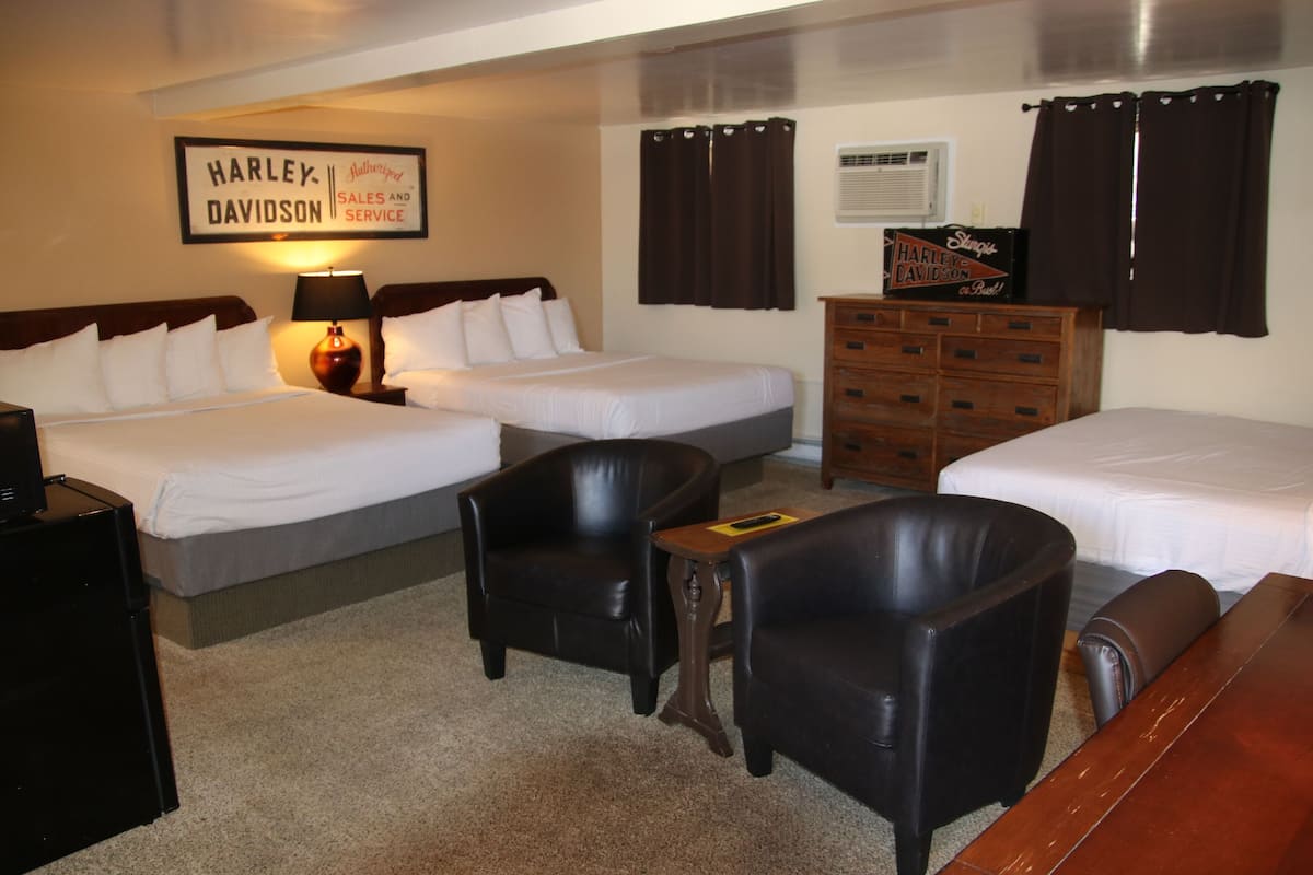 Ein Hotelzimmer mit zwei Betten, einem Schminktisch, einem Schreibtisch und einem Stuhl.