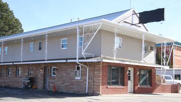 A two-story building with a flat roof, a brick base, and a white exterior.