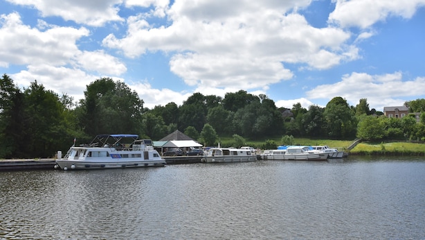 A calm lake with several boats docked, surrounded by trees and a clear sky. - Villa in Crux-la-ville Near Morvan Park (Crux-la-Ville)