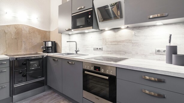 A modern kitchen with grey cabinetry, a Bosch oven, a built-in microwave, and a coffee maker. - Holiday Home in Rennweg Near Ski Slopes (Rennweg am Katschberg)
