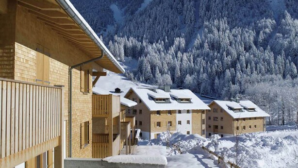 A wooden building with multiple balconies and a mountain backdrop. - Vibrant Apartment near Ski Slopes in Brand (Brand)