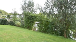 A grassy area with trees and a building in the background. - Holiday Home in Harderwijk Near Serene Lake (Zeewolde)