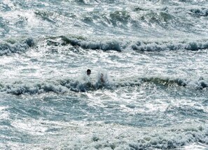 Une personne nageant dans les vagues agitées de l’océan.