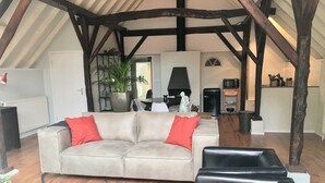 A cozy living room with a sofa, a coffee table, and a fireplace. - Boutique Holiday Home in Nieuwleusen near Forest (Nieuwleusen)