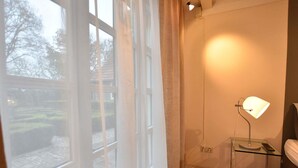 A room with a large window, a clear view of the outdoors, a bedside table with a lamp, and a bed. - Boutique Holiday Home in Nieuwleusen near Forest (Nieuwleusen)
