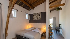 A bedroom with a large bed, two bedside lamps, a small table, and a chair. - Holiday Home in Koudekerke Near Seabeach (Koudekerke)
