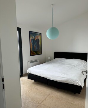 A bedroom with a bed, a painting, a heater, and a light fixture. - Villa in Malaucene With Private Pool (Malaucene)