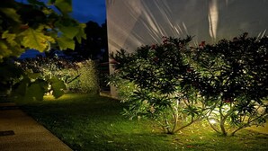 A garden area with well-maintained grass and shrubs, a pathway, and a large white tent-like structure. - Villa in Malaucene With Private Pool (Malaucene)