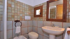 A bathroom with a bidet, toilet, sink, and a mirror. - Residence a Badesi 3375 (Badesi)