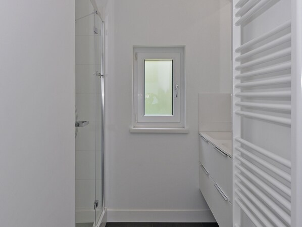 A small, narrow bathroom with a window, a shower, and a built-in towel rack. - Holiday Home in Kamperland by Veerse Meer (Kamperland)