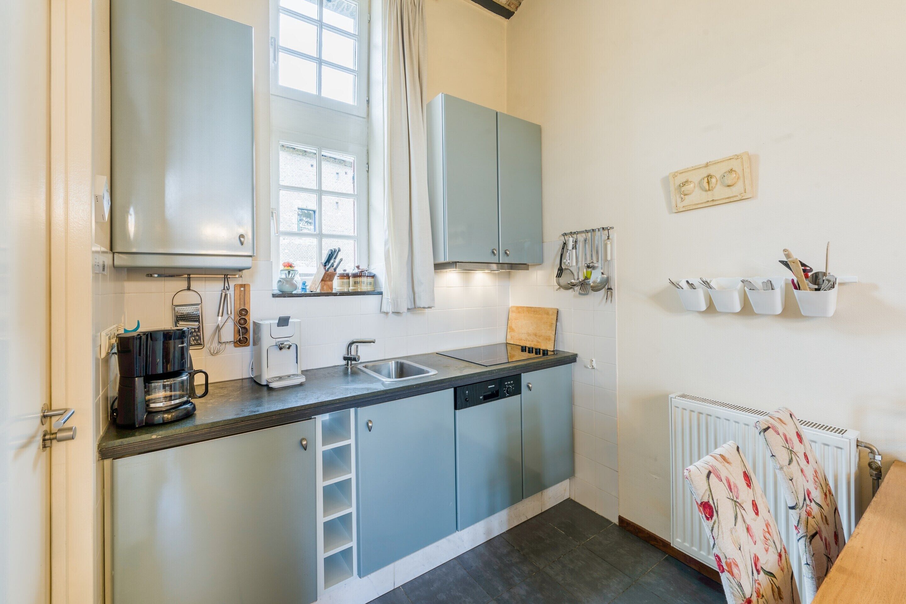 Appartement | Privékeuken | Een kinderstoel, kookgerei, borden en bestek