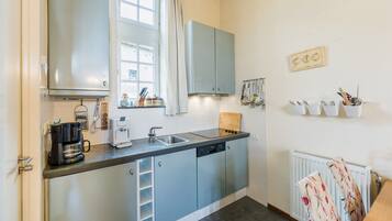 Appartement | Privékeuken | Een kinderstoel, kookgerei, borden en bestek