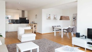 A modern apartment with a kitchen, dining area, and living room. - Sunlit Retreat With Balcony (The Hague)