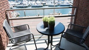 A balcony with two chairs and a table, overlooking a marina with numerous boats. - Sunlit Retreat With Balcony (The Hague)