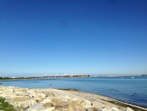 A coastal landscape with a rocky shoreline, calm water, and a clear sky. - Denneville Coastal Escape With Garden (Port-Bail-sur-Mer)
