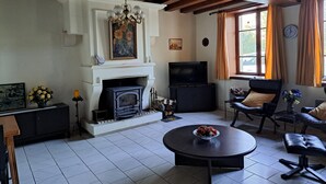 A living room with a fireplace, a television, a round coffee table, and a comfortable seating area.