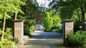 A pathway leading to a building with 'Gerner' signs on brick pillars. - Attractive Holiday Home with Large Garden near Zwolle (Dalfsen)