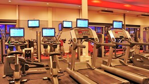 Et fitnesscenter med løbebånd, styrkemaskiner og konditionsudstyr.