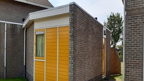 En lille, etetages bygning med murstensfacade og en gul frontvæg.