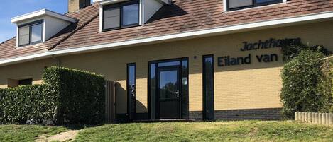 A two-story building with a sign reading "Jachthuis Eiland van."