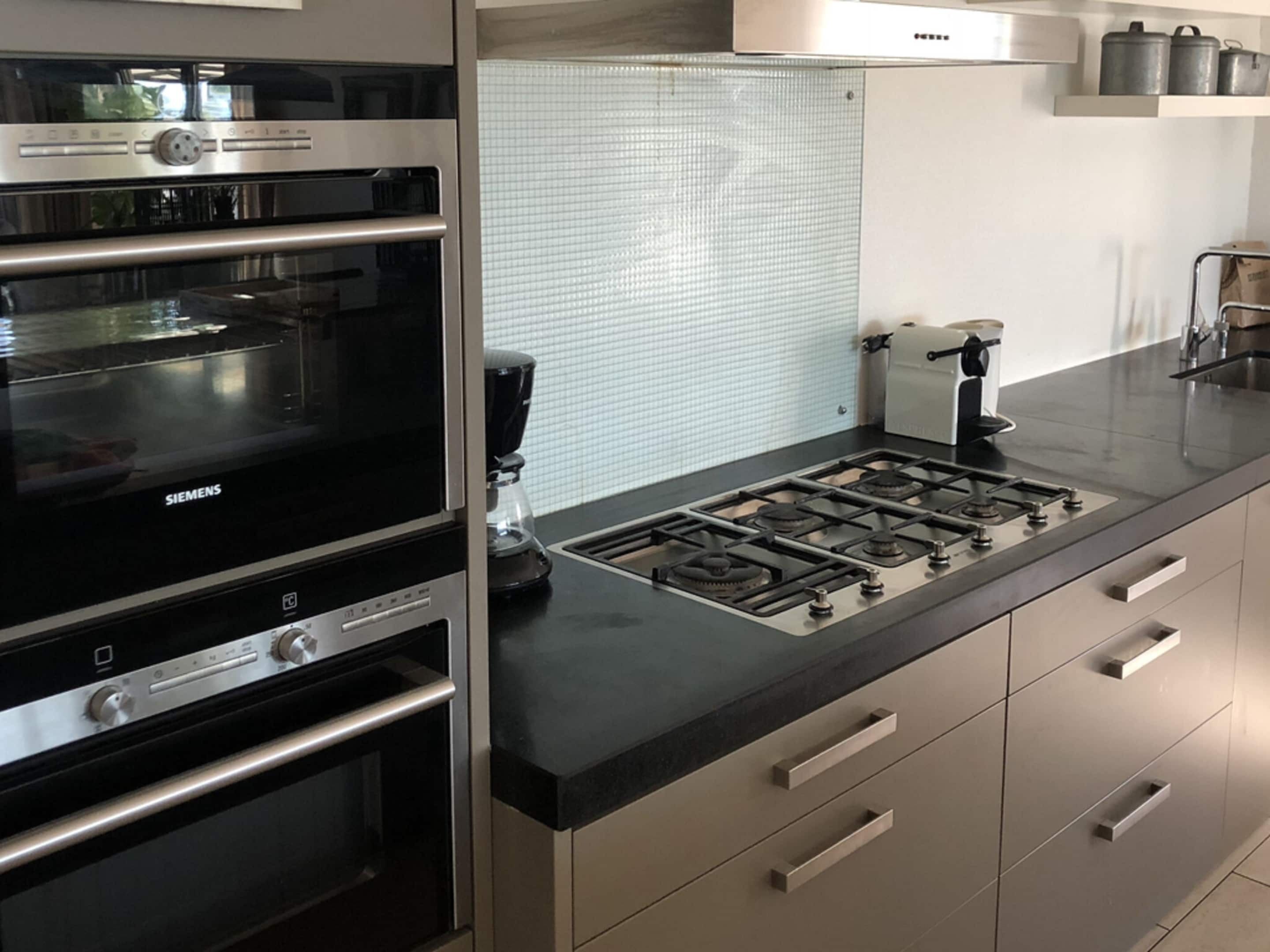 A kitchen with a Siemens oven, a coffee maker, and a gas stove.