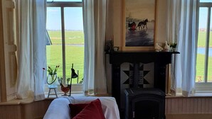 Um quarto com cama, lareira e uma pintura de cavalos.