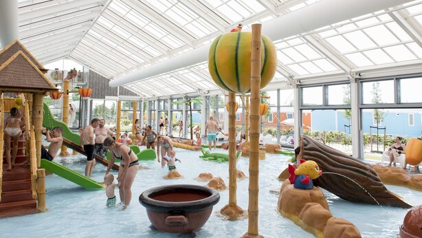 Un parc aquàtic interior amb tobogans, jocs i una gran atracció d'aigua.