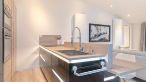 A modern kitchen with a central island, stainless steel appliances, and a minimalist design. - Cozy Chalet with Fireplace near Oosterschelde (Wemeldinge)