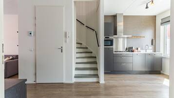 A modern kitchen with a built-in oven, a stainless steel range, and a window above the sink.