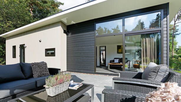 Un espacio exterior moderno con sofá, sillones y una mesa de centro.