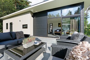 A modern outdoor living area with a sofa, chairs, and a coffee table. - Modern Chalet With a Smart TV Near Forest (Markelo)