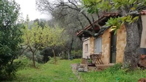 A rustic stone building with a wooden deck and a small table.