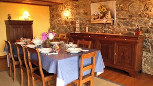 A dining area with a stone wall, wooden furniture, and a table set for six.