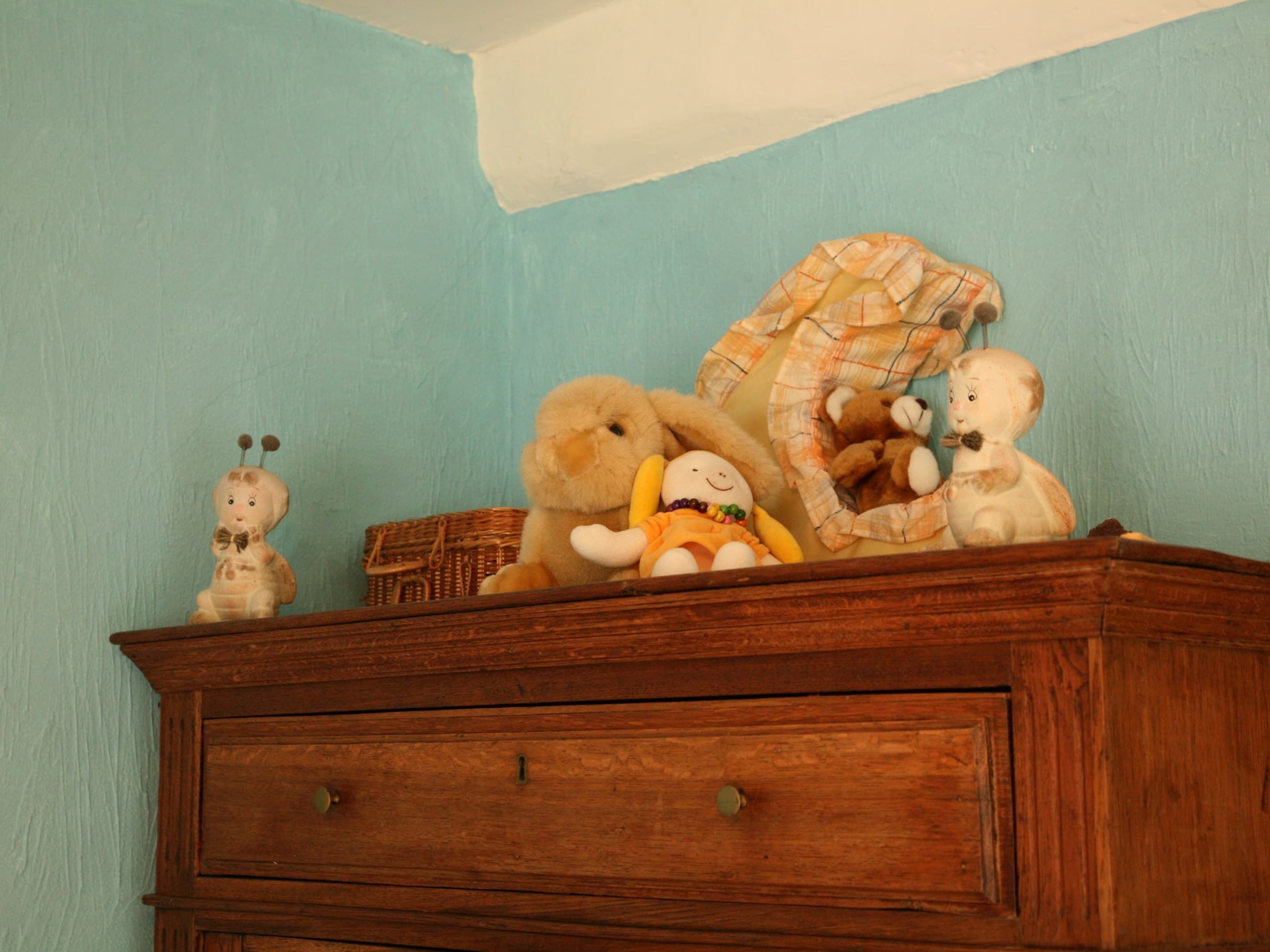 A wooden dresser with a light blue wall in the background.